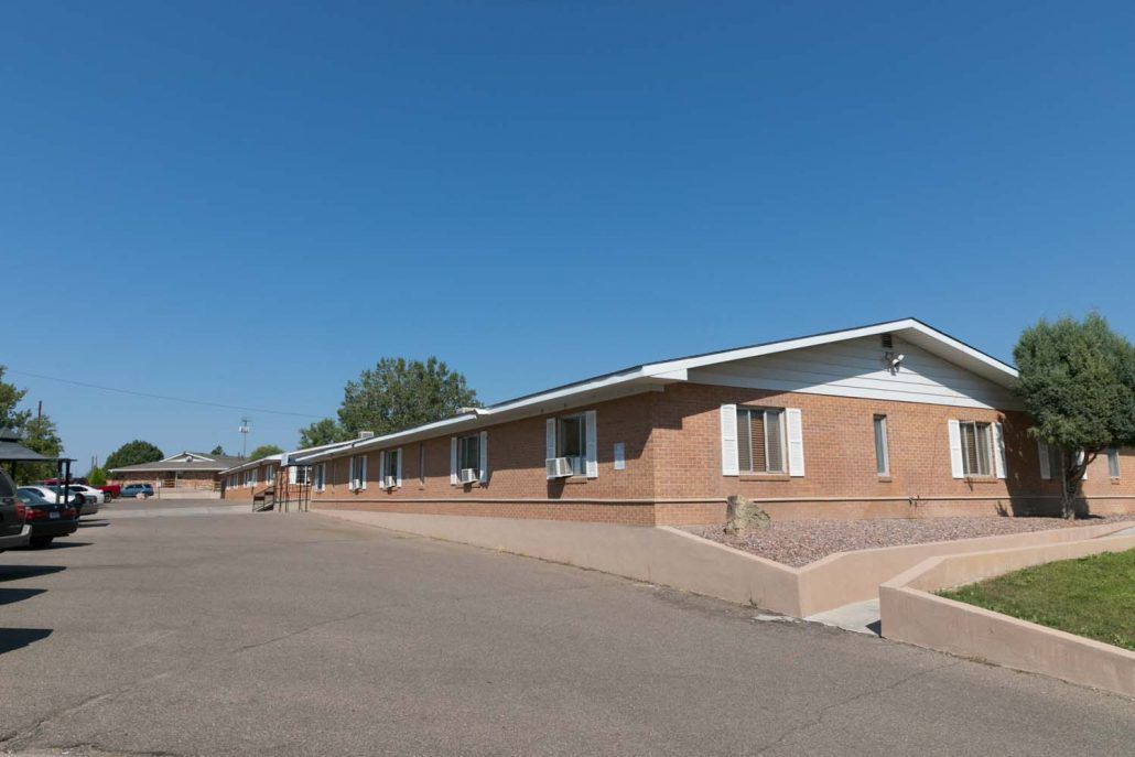 A brick motel building under a clear blue sky.