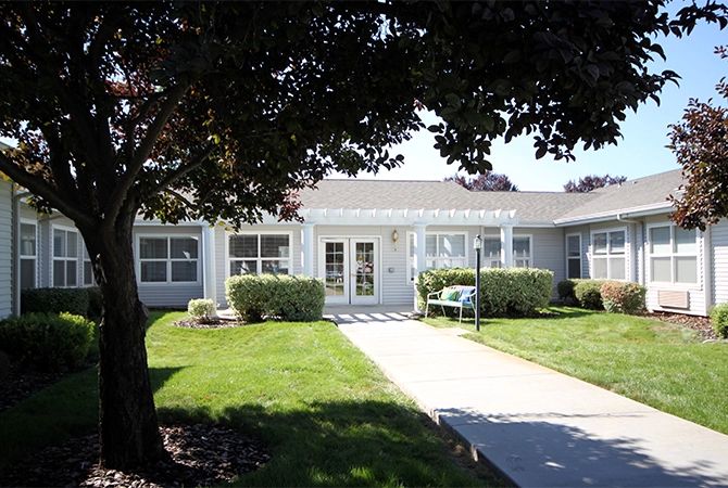 A single-story house with a well-maintained lawn and pathway leading to the entrance.