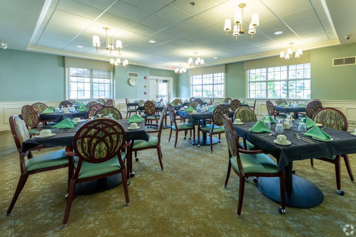 Elegant dining area with neatly arranged tables and classic chandeliers.