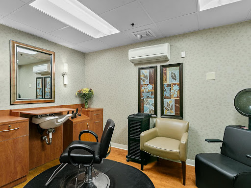 A cozy salon interior featuring a haircut station, comfortable seating, and an elegant decor.
