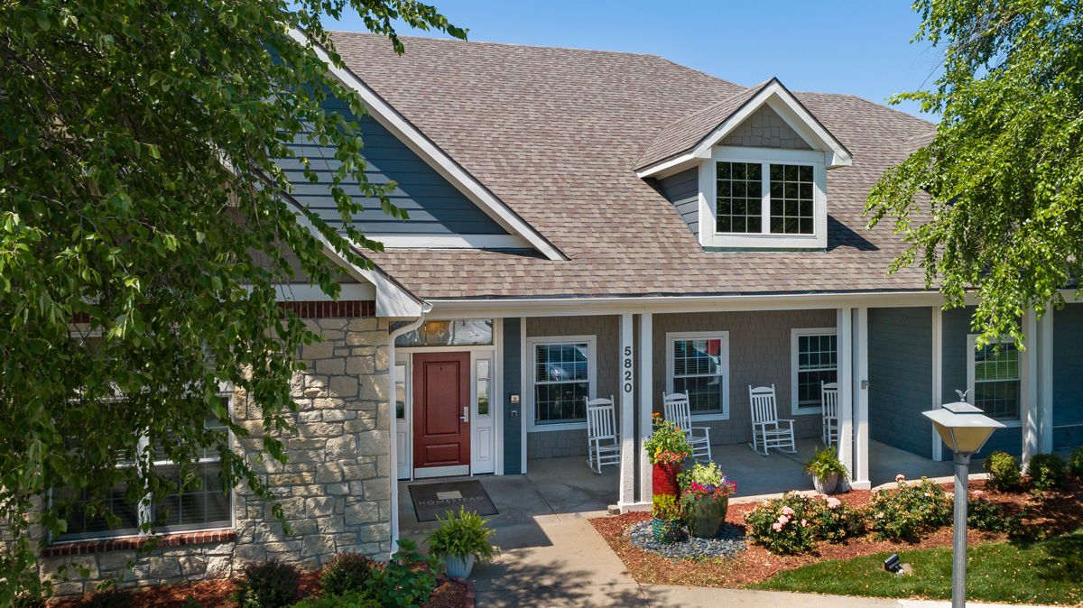 A charming suburban house with a landscaped front yard and cozy front porch.