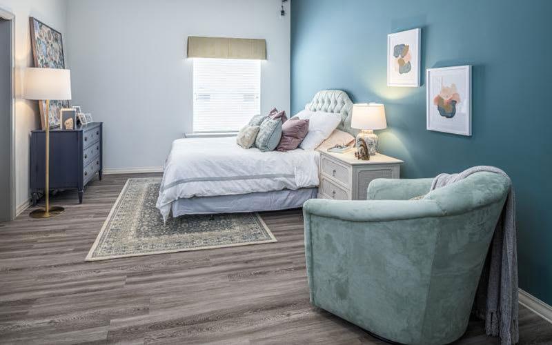 A modern and cozy bedroom with a blue accent wall and stylish decor.
