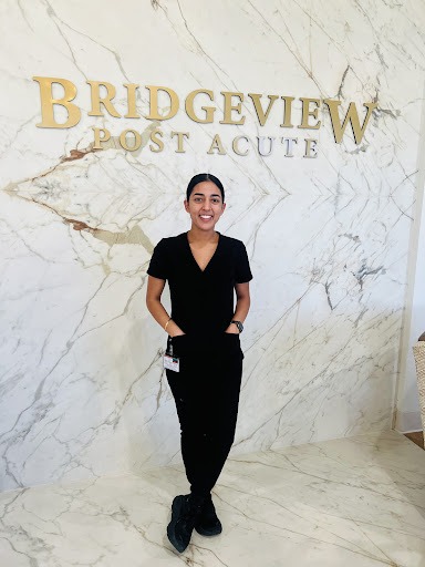 A healthcare professional standing proudly in the Bridgeview Post Acute facility.