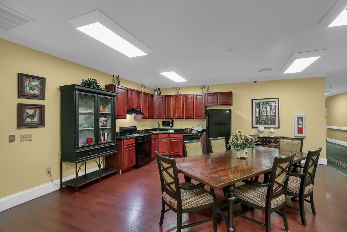 Cozy kitchen and dining area with wooden cabinets and a round table.