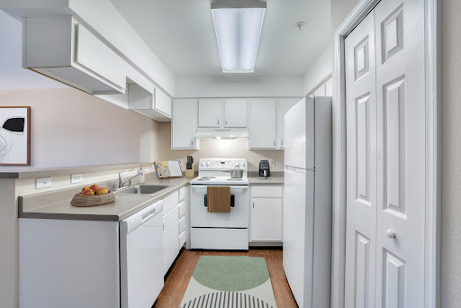 A bright and modern kitchen featuring white cabinets and appliances, showcasing a clean and inviting atmosphere.