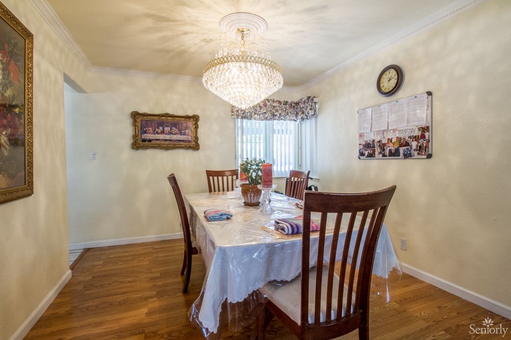 A dining room featuring a chandelier, table with chairs, and decorative elements.