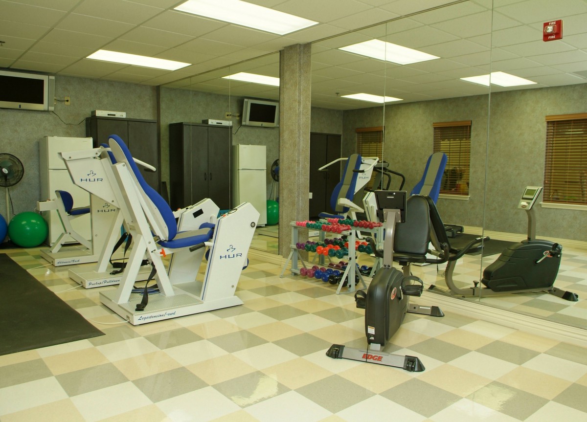 A gym room equipped with various exercise machines and weights.