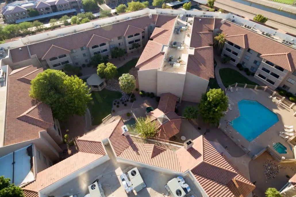 Aerial view of a residential complex with a pool and landscaped surroundings.