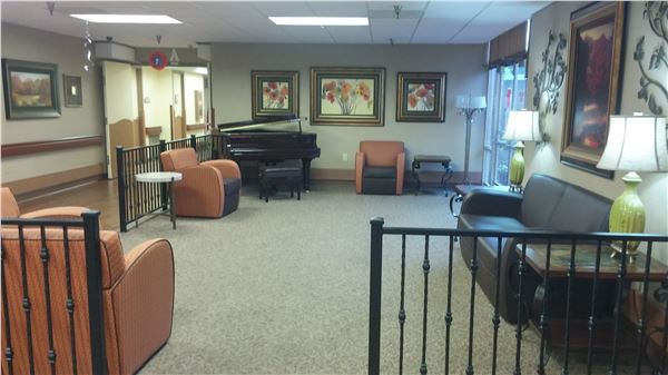 A lobby featuring seating arrangements and a piano.