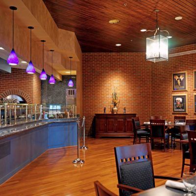 A cozy restaurant interior featuring a buffet setup with warm lighting and wooden furnishings.