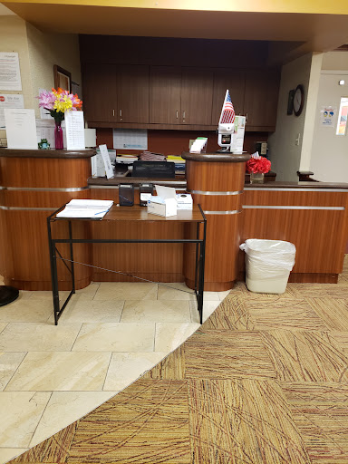 A view of a hotel lobby reception area featuring a wooden desk and organizational items.