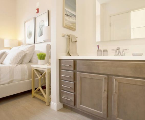 A modern bedroom seamlessly connected to a bathroom, featuring stylish furniture and cozy decor.
