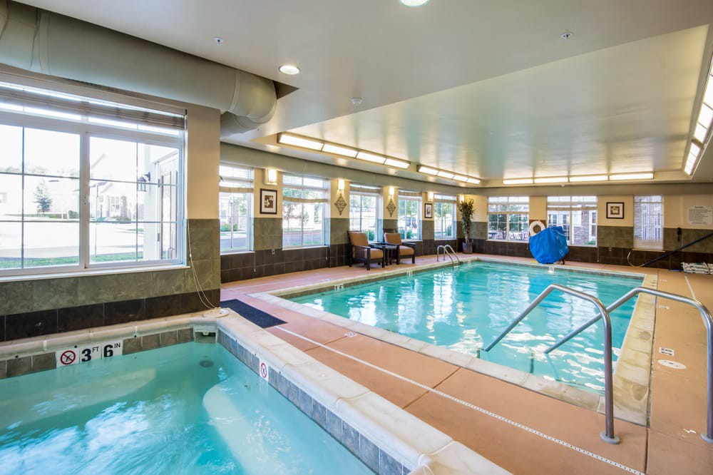 A serene indoor swimming pool and jacuzzi area in a hotel.