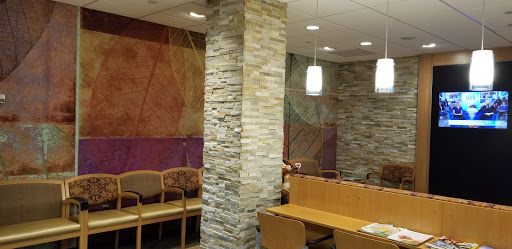A modern waiting area featuring a stone pillar and contemporary seating arrangements.