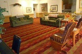 A cozy living room with green sofas and a patterned carpet.