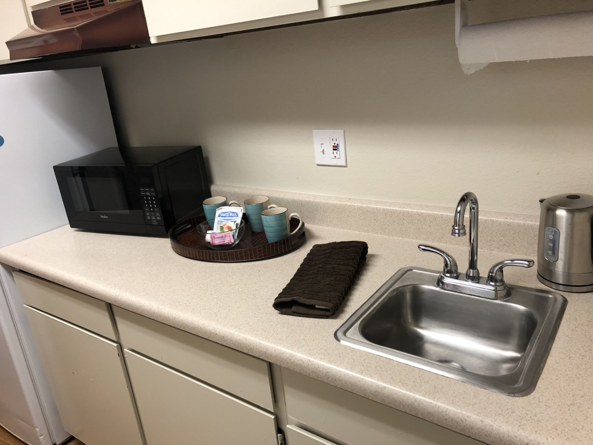 A small office kitchenette with a coffee maker and sink.