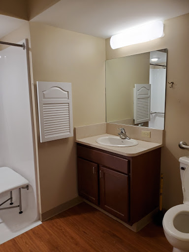 A simple and clean bathroom featuring a sink, toilet, and shower area.