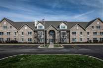 A symmetrical brick residential building under a clear blue sky.