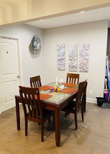 A cozy dining room setup with a wooden table and chairs, complemented by wall art and decor.