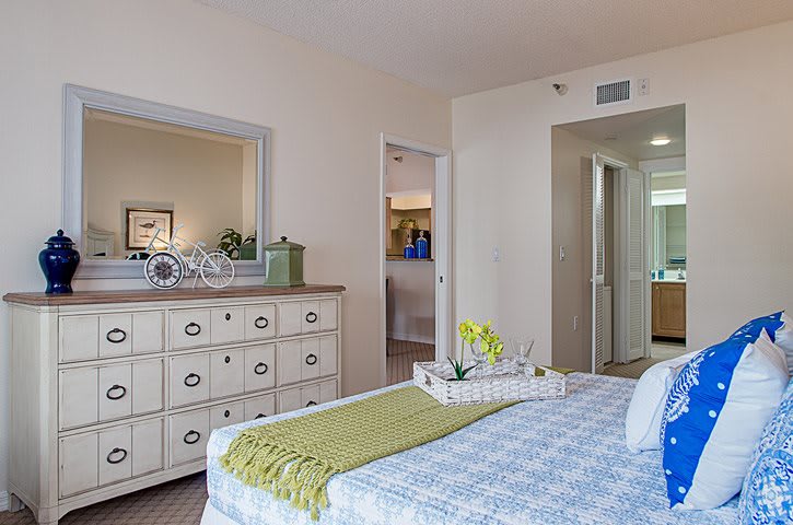 A cozy and modern bedroom interior with a neatly made bed and a stylish dresser.
