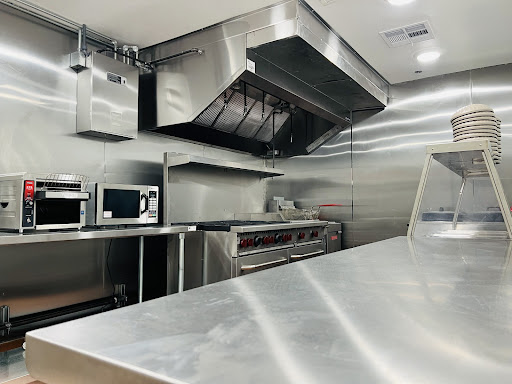 A modern and clean commercial kitchen equipped with stainless steel appliances.