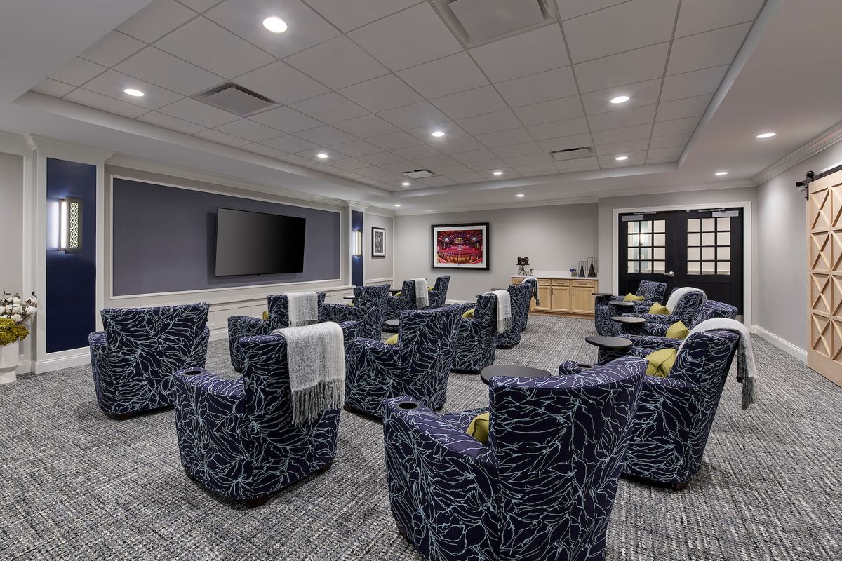 A modern conference room with comfortable seating and a large television for presentations.
