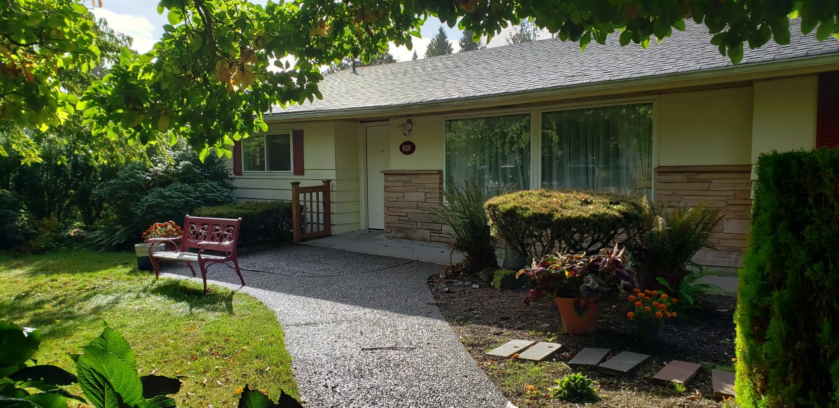 A quaint house with a well-maintained garden and pathway leading to the front door.