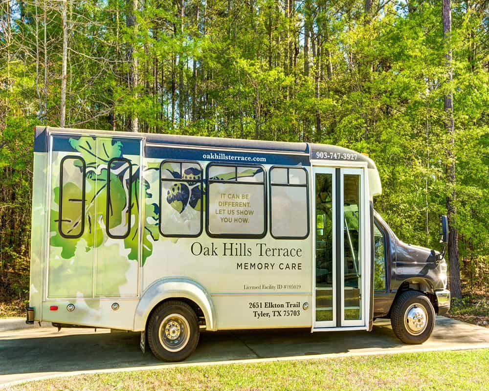 A decorated shuttle bus parked in a scenic outdoor environment.