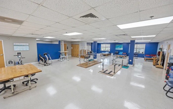 A spacious rehabilitation center equipped with exercise and physical therapy apparatus.