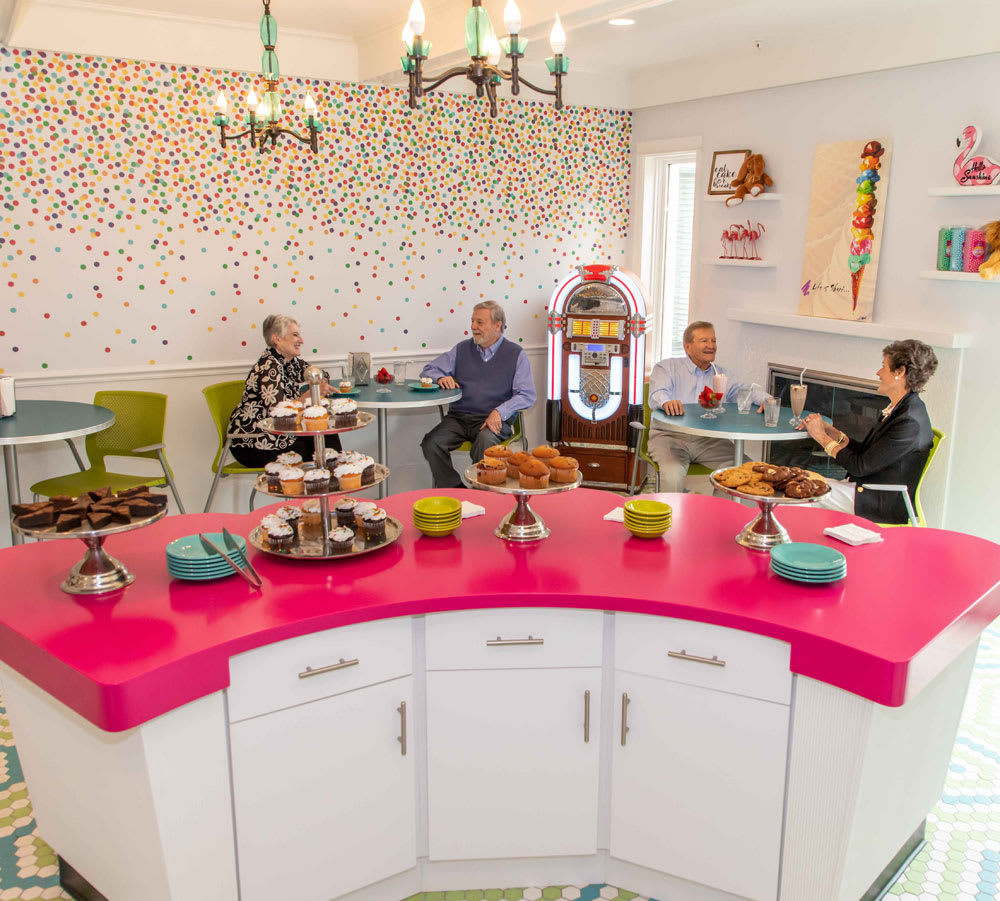 A group of people enjoying a retro-themed diner with vintage decor and a jukebox.