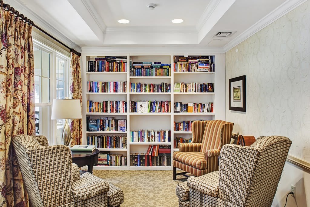 A cozy reading area with bookshelves full of books and comfortable armchairs.