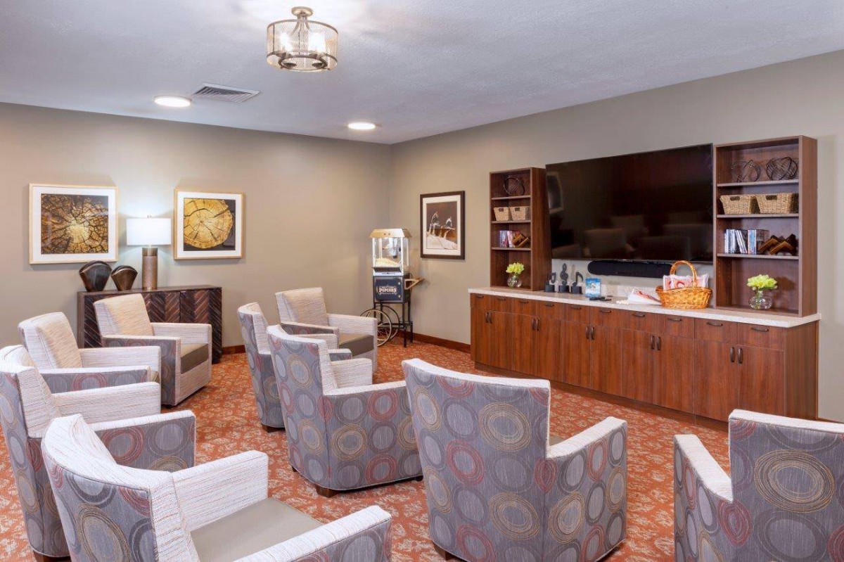 A comfortable waiting room with multiple chairs, a television, and a bookcase.