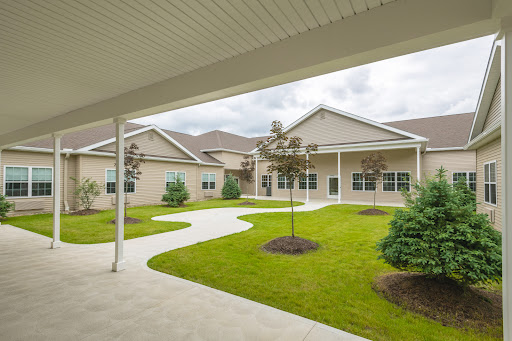 A serene courtyard surrounded by modern buildings, featuring manicured lawns and pathways.