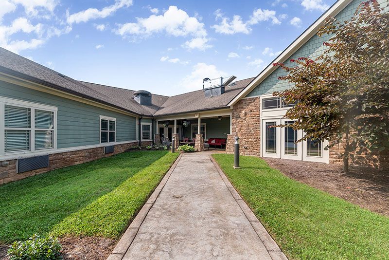 A modern residential house with a well-maintained lawn and pathway leading to the entrance.