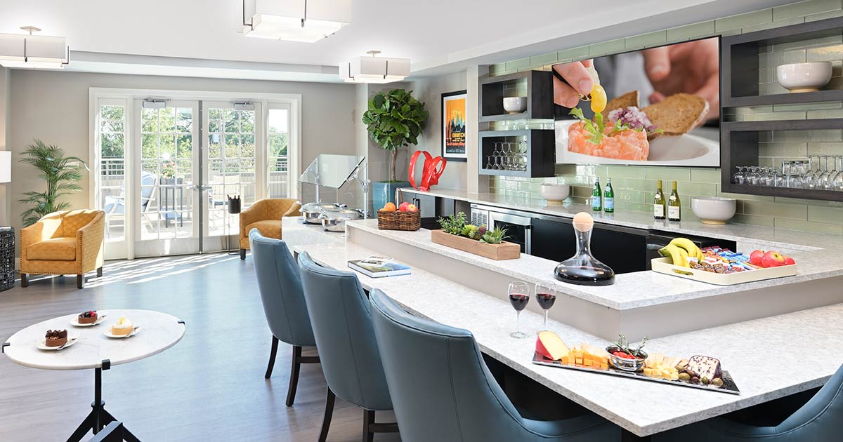 A modern kitchen with a sleek countertop and stylish bar stools, featuring contemporary decor.