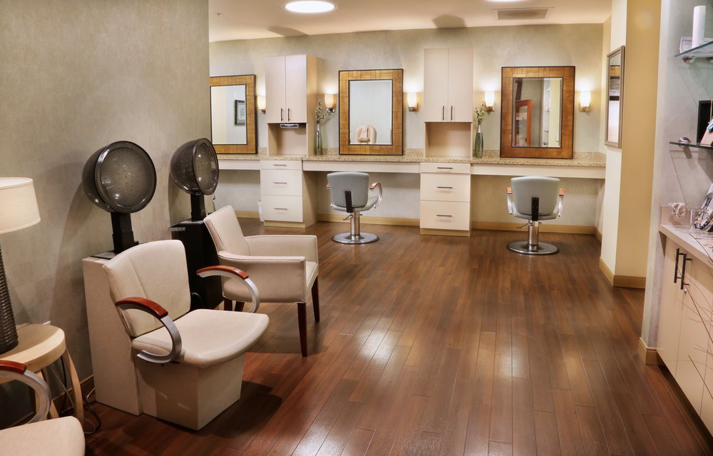 An elegant hair salon interior with styling chairs and large mirrors.