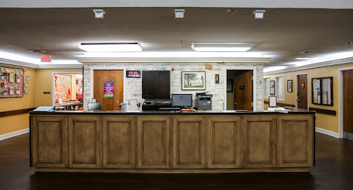 A modern reception area featuring a wooden counter and office equipment.