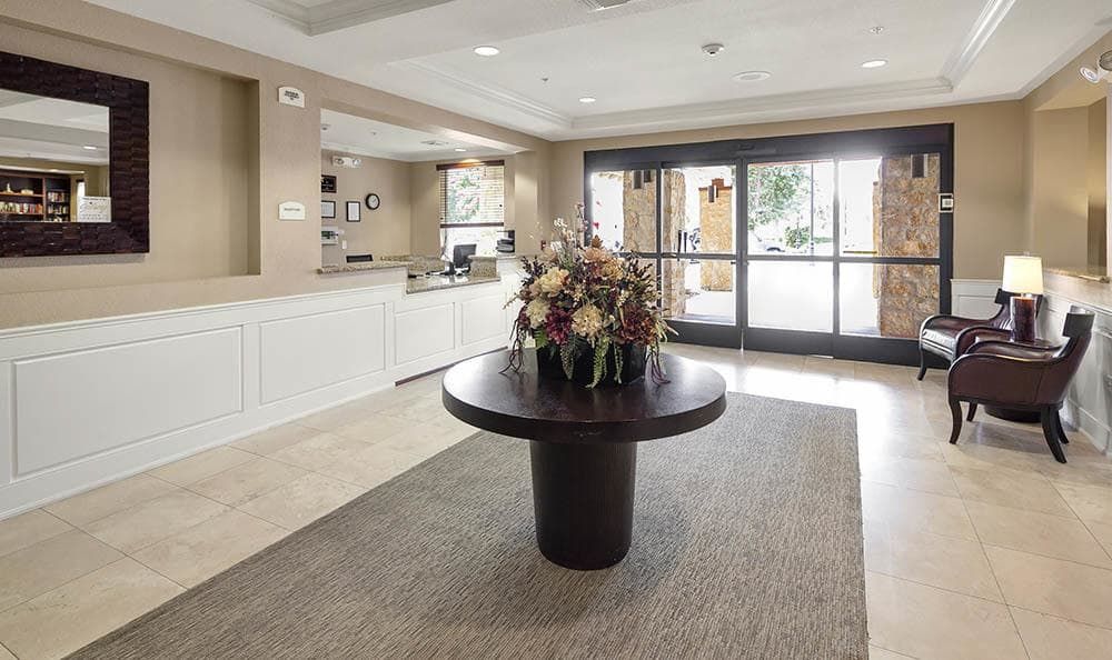 A welcoming lobby with a central table featuring a floral arrangement.