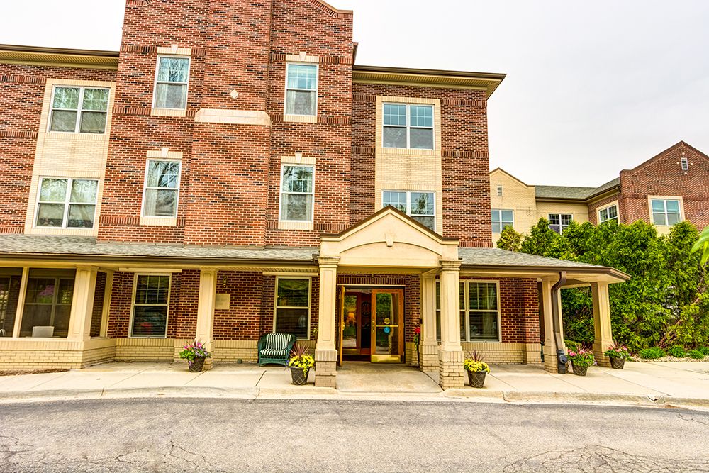 A three-story brick building with a covered entrance and multiple windows.