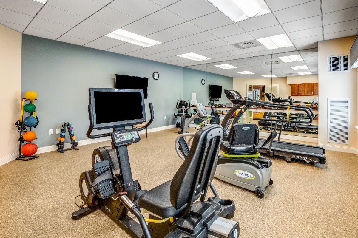 A modern gym with various exercise equipment, including treadmills and stationary bikes.