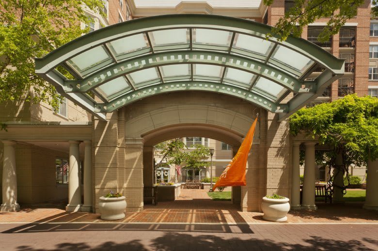 An elegant building entrance with a glass canopy and archway.