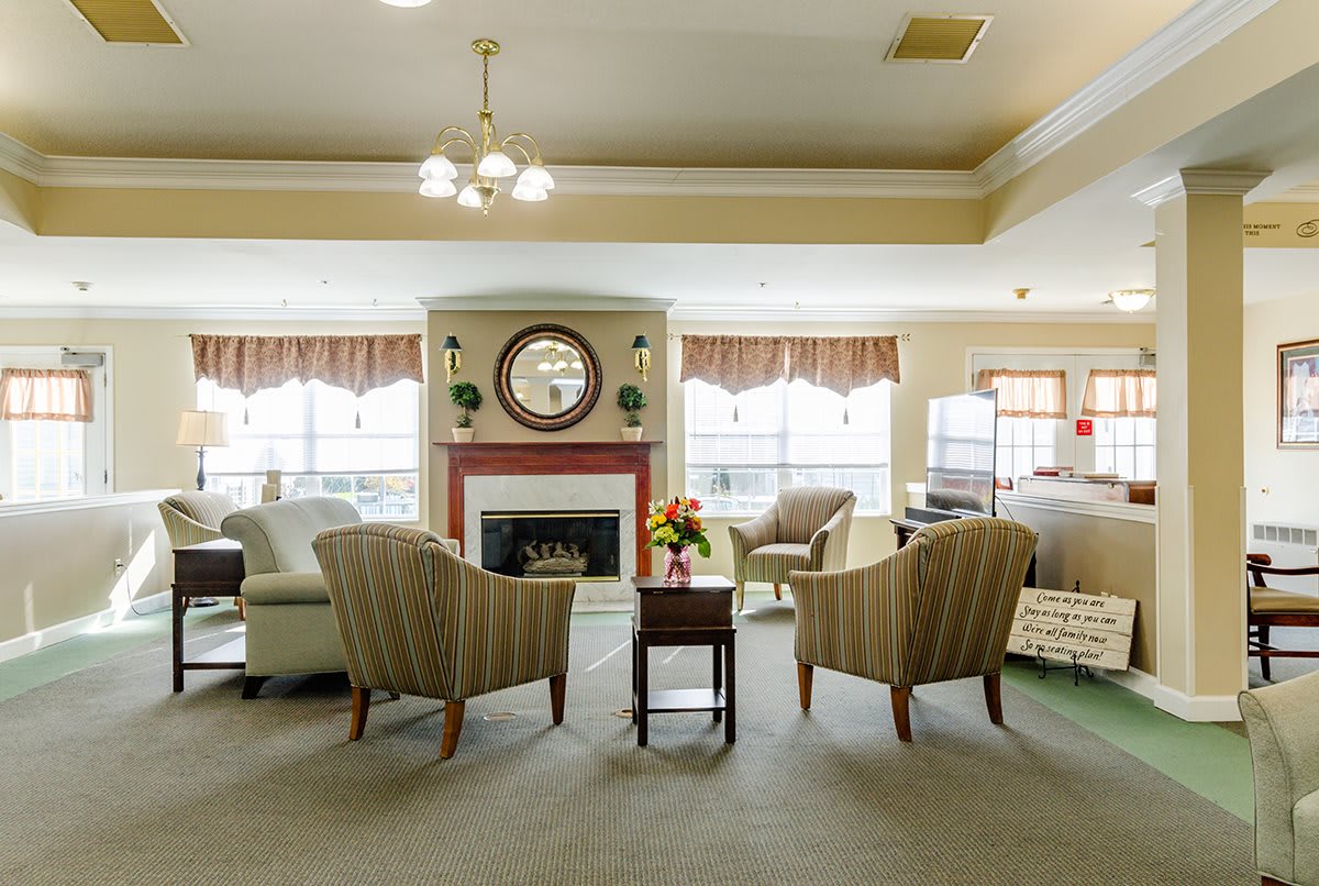 A cozy living room with a fireplace, comfortable seating, and warm lighting.