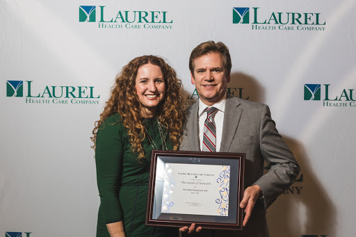 Celebrating achievement at the Laurel event with a certificate of recognition.