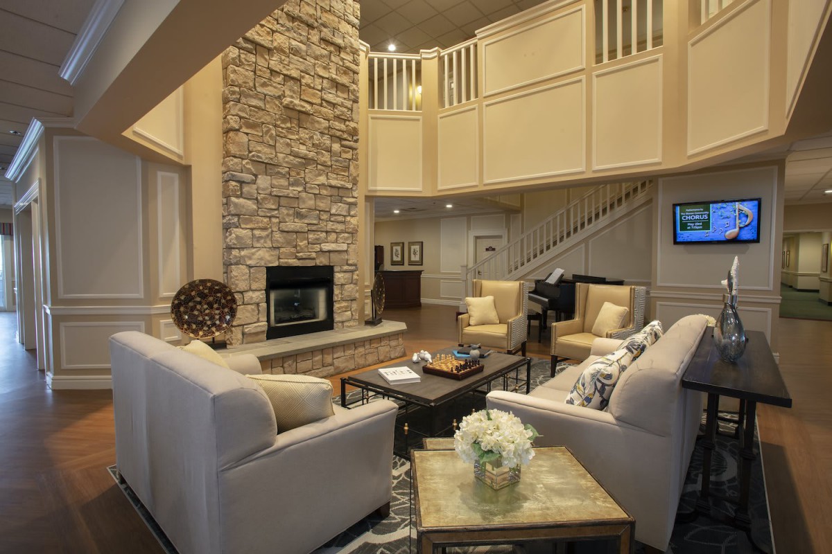 A modern living room featuring a stone fireplace, comfortable seating, and elegant decor.