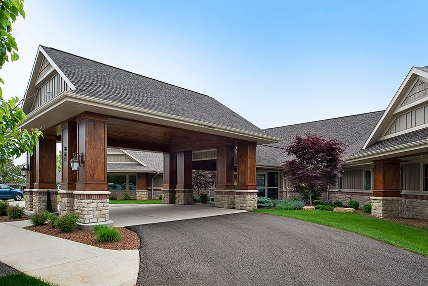 A building with a covered entrance and landscaped surroundings.