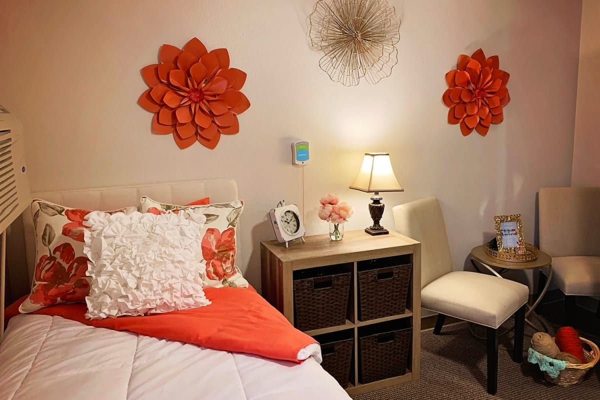 A cozy bedroom featuring orange wall decorations and warm lighting.