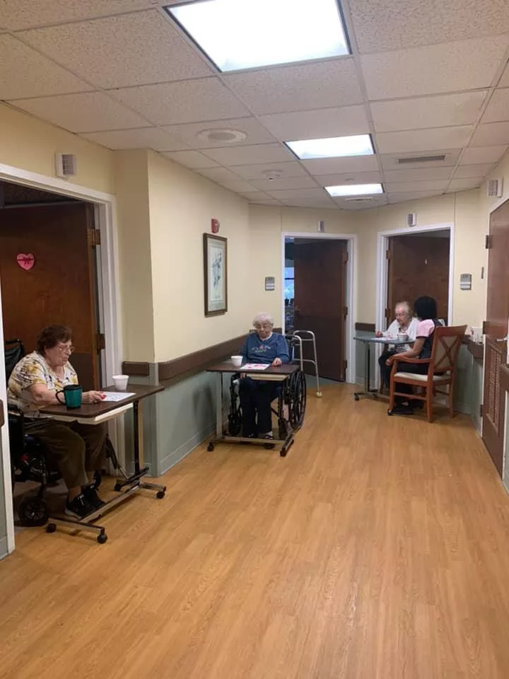 Elderly residents sitting in the hallway of a nursing home.