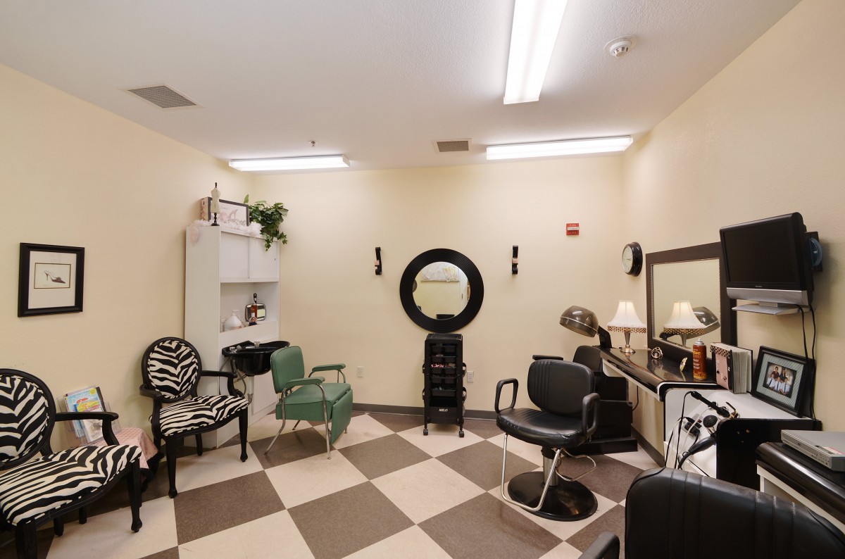 A cozy hair salon with various styling chairs and mirrors, featuring a checkered floor design.