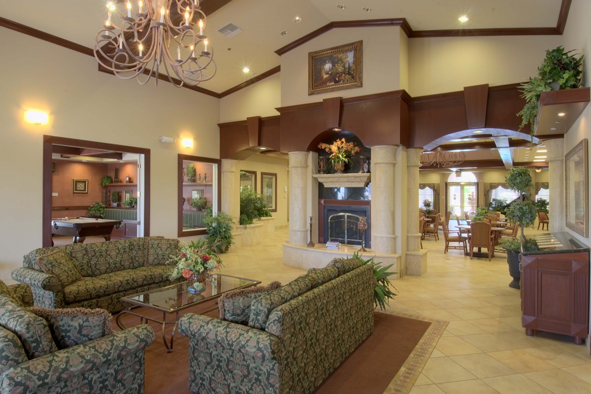 A luxurious living room with elegant furniture, a grand chandelier, and a cozy fireplace.