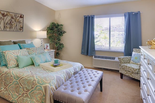 A cozy and well-decorated bedroom featuring a comfortable bed, soft lighting, and elegant curtains.